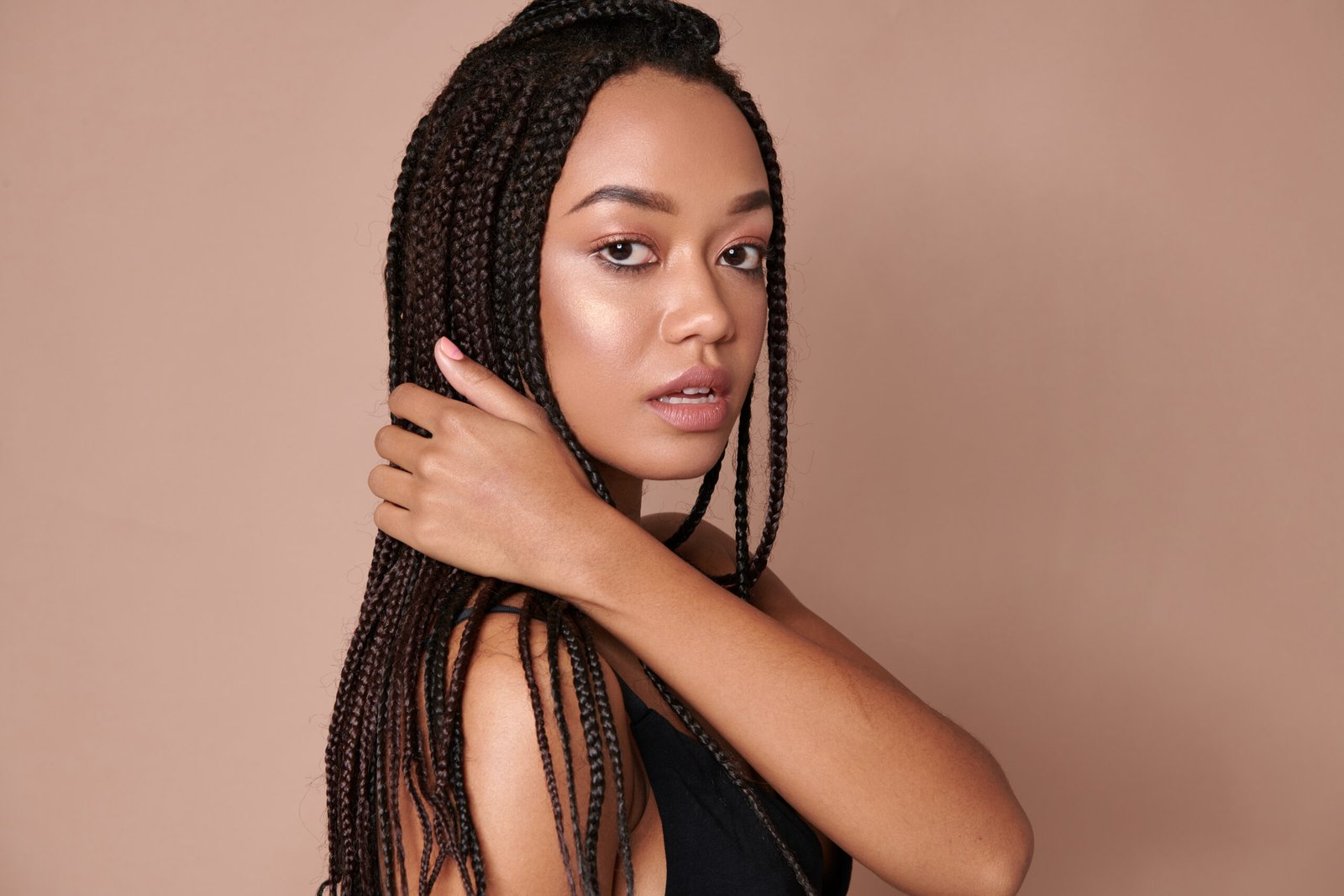 Woman with braids resting her head on her arms
