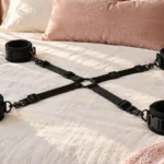 Four padded cuffs and woven straps displayed on a cream linen bed.